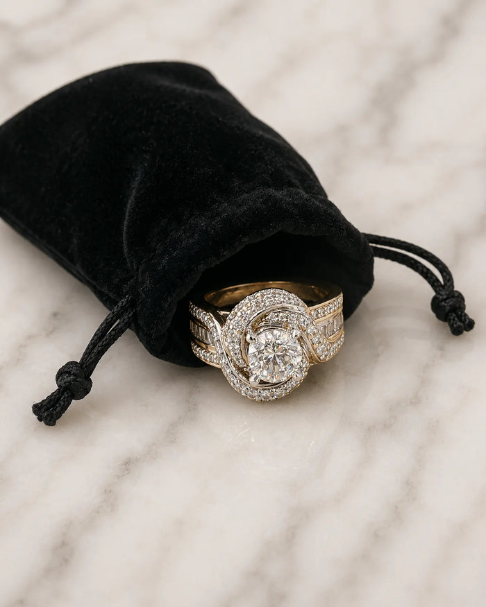 Diamond ring stored in a black velvet jewellery pouch on pale marble